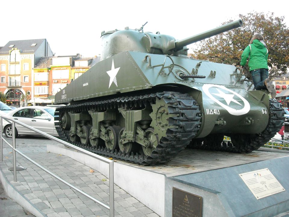 Green tank with white star emblem and tracks, viewed from the rear