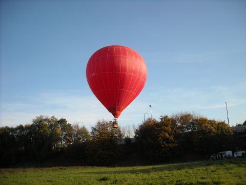 1979 Ford F-150 - A bright red hot air balloon ascends into the clear blue sky on a sunny day.