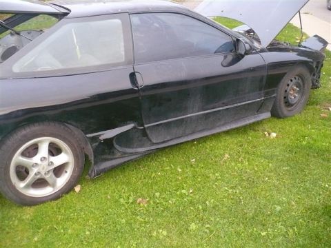 1993 Ford Probe - Side view of a black 1993 Ford Probe coupe with its hood open, sitting on a grassy area.