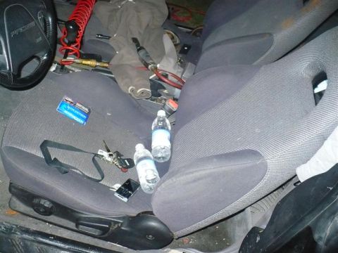 1993 Ford Probe - The interior of a 1993 Ford Probe is visible, the driver's seat and passenger seat with personal items scattered about.