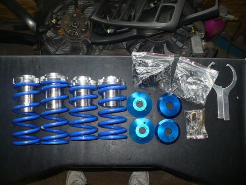 1993 Ford Probe - A set of adjustable coilover suspension parts, including springs and mounting hardware, are displayed on a table.