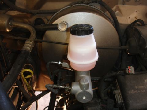 1992 Ford F-350 - Close-up of a master cylinder reservoir and brake booster assembly in a 1992 Ford F-350.