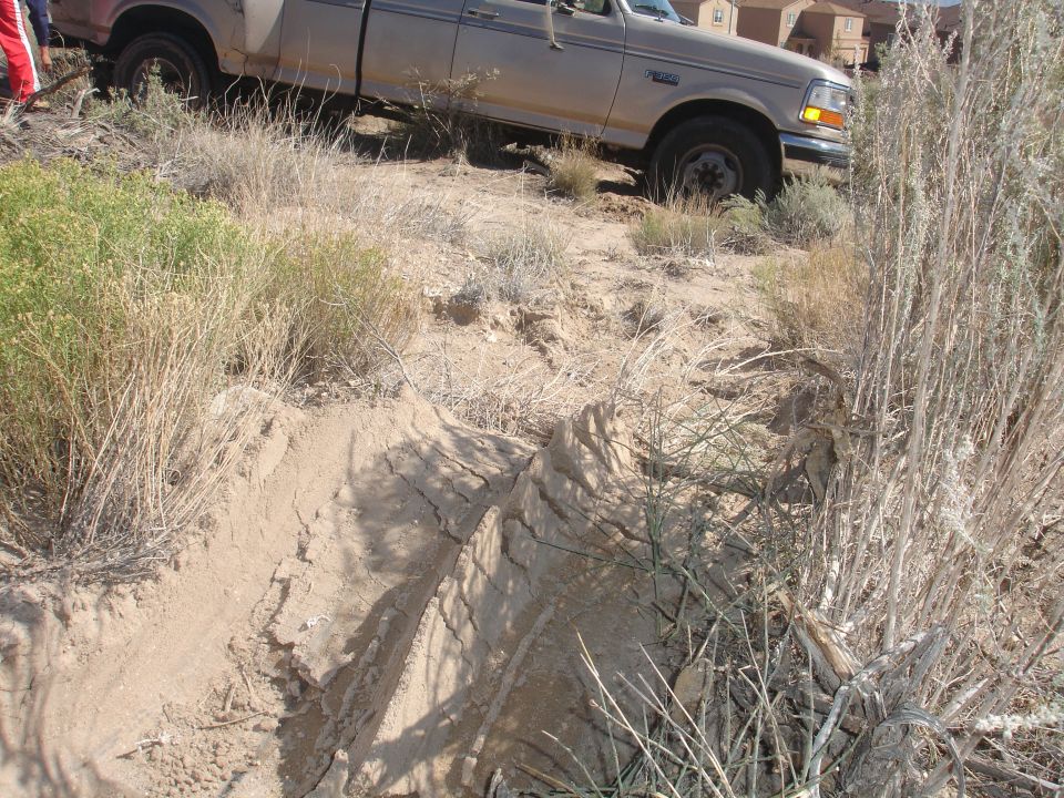 Tan 1992 Ford F-350 truck stuck in dirt, viewed from the front three-quarter angle