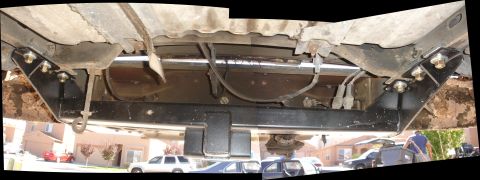 1992 Ford F-350 - Undercarriage view of a truck's trailer hitch assembly, with other vehicles visible in the background.