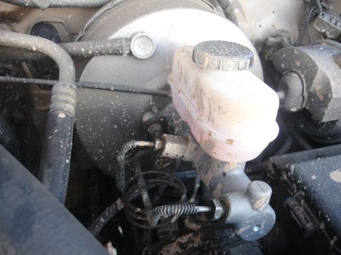 1992 Ford F-350 - Close-up view of a brake master cylinder and fluid reservoir, covered in dust.