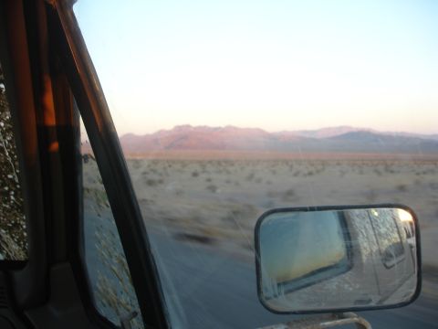 1992 Ford F-350 - Driving through a desert landscape at sunset, with mountains visible on the horizon.