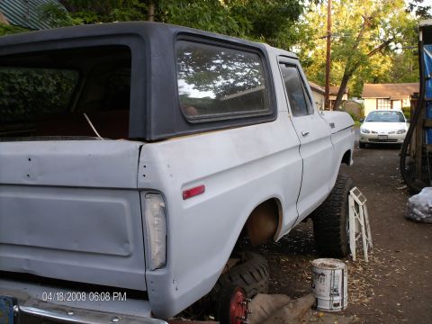 1979 Ford Bronco - This 1979 Ford Bronco is shown in primer with a black hardtop. A white sedan is visible in the background.