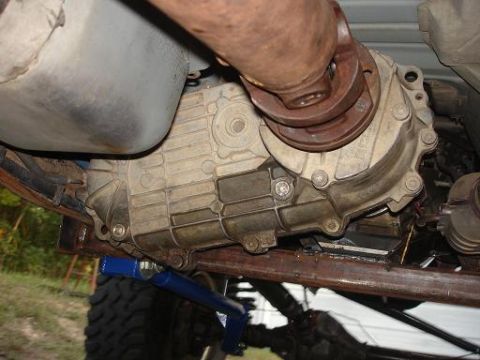 1996 Ford F-150 - Close-up of the vehicle's transfer case and driveshaft components, with a blue jack visible underneath.