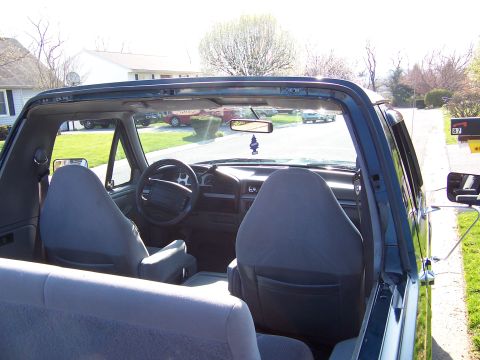 1995 Ford Bronco - The interior of a 1995 Ford Bronco is visible from the rear, looking forward towards the dashboard and front seats.