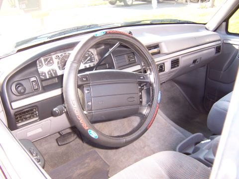 1995 Ford Bronco - The interior of the vehicle shows the dashboard, steering wheel, and passenger seat.