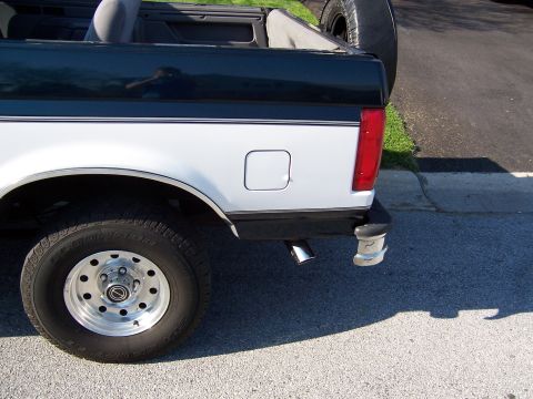 1995 Ford Bronco - Rear view of a two-tone Ford Bronco, showing its spare tire and rear bumper details.