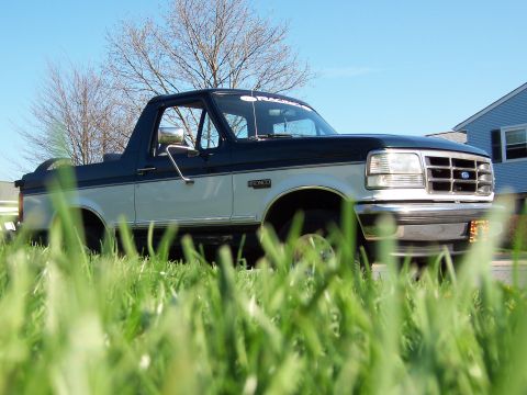 1995 Ford Bronco - This two-tone 1995 Ford Bronco is seen from a low angle, partially obscured by grass.