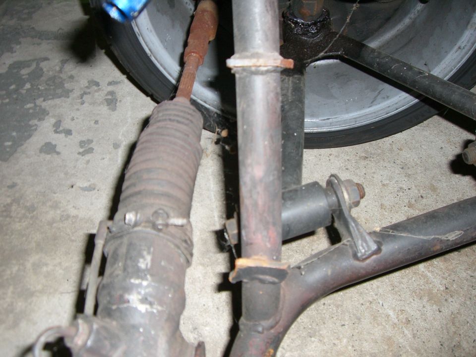 Steering rack with bellows and suspension linkage