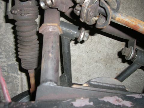1988 Ford Bronco - Undercarriage view shows various metal components and a rubber bellows, likely part of a vehicle's steering or suspension system.