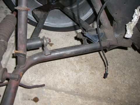 1988 Ford Bronco - This photo shows a close-up view of vehicle suspension components, including a metal rod and wiring.
