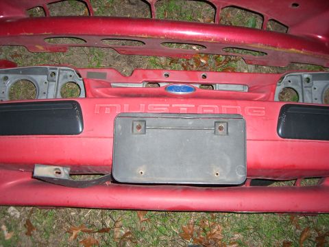 1988 Ford Bronco - Front bumper assembly for a Ford Mustang, embossed lettering and the iconic blue Ford oval emblem.
