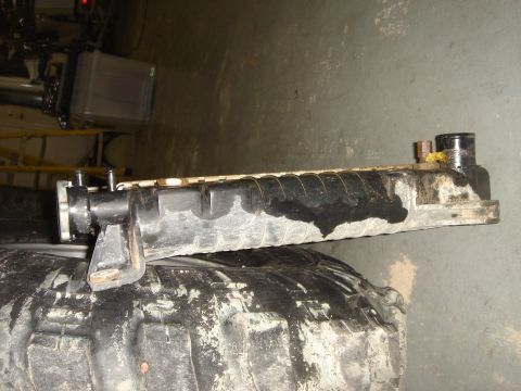 1996 Ford Bronco - A vehicle radiator is shown placed on top of a dirty tire, with visible signs of wear and staining.