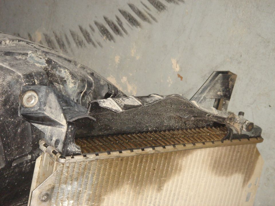 Close-up of a damaged radiator with black plastic housing