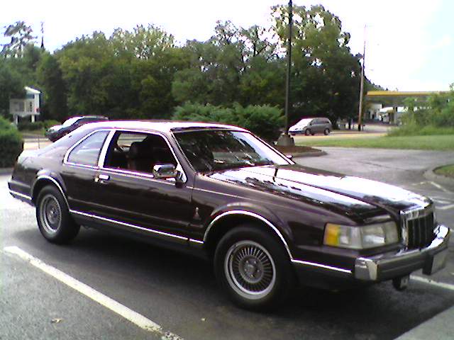 Dark maroon Lincoln Mark VII two-door coupe parked in a lot