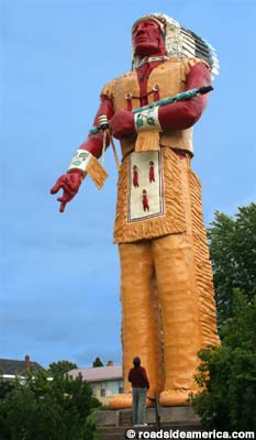 1971 Ford Ranchero - A colossal statue of a Native American man stands tall against a blue sky, with a small figure at its feet for scale.