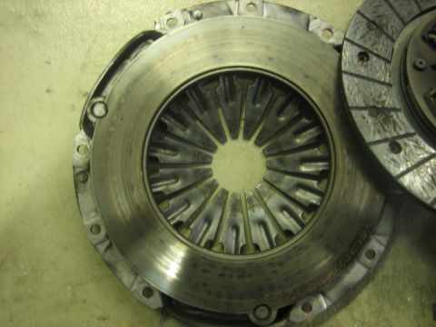 1995 Mitsubishi Eclipse - A close-up view of a clutch pressure plate, showing some part numbers and wear.