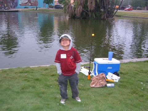 1988 Ford Bronco - A young boy stands by a lake with his fishing gear, ready for a day of angling.