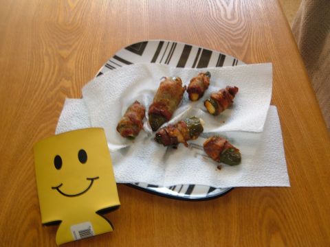 1988 Ford Bronco - Plate of bacon-wrapped jalapeños with a smiley face koozie on a wooden table.