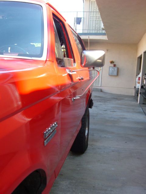 1988 Ford Bronco - Side profile of a red 1988 Ford Bronco showing the door and fender.