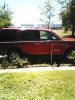 2004 Ford Explorer - A red SUV is parked outside on a sunny day, with green grass and trees visible.