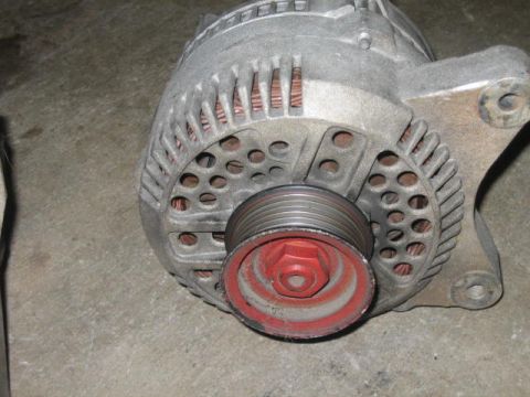 1996 Ford Thunderbird - Close-up of a vehicle alternator with a red pulley.