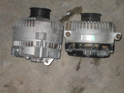 1996 Ford Thunderbird - Two automotive alternators are shown on a concrete surface.