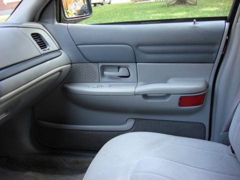 2003 Ford Crown Victoria - Interior view of a 2003 Ford Crown Victoria's passenger door panel, revealing the gray upholstery and controls.