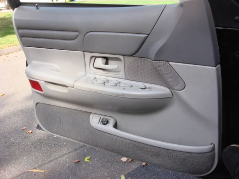 2003 Ford Crown Victoria - The interior door panel of a 2003 Ford Crown Victoria, power window and lock controls.