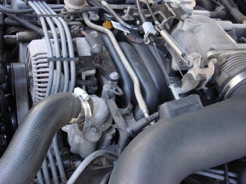 2003 Ford Crown Victoria - Close-up view of an engine bay, showing the alternator, intake manifold, and various hoses and wires.
