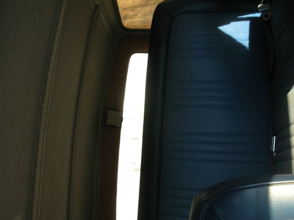 Interior view of a 1979 Ford Bronco showing blue vinyl seats and door panel