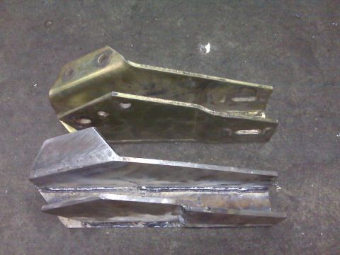 1980 Ford Bronco - Comparison of two metal brackets, one finished and one raw steel, likely for vehicle modification.