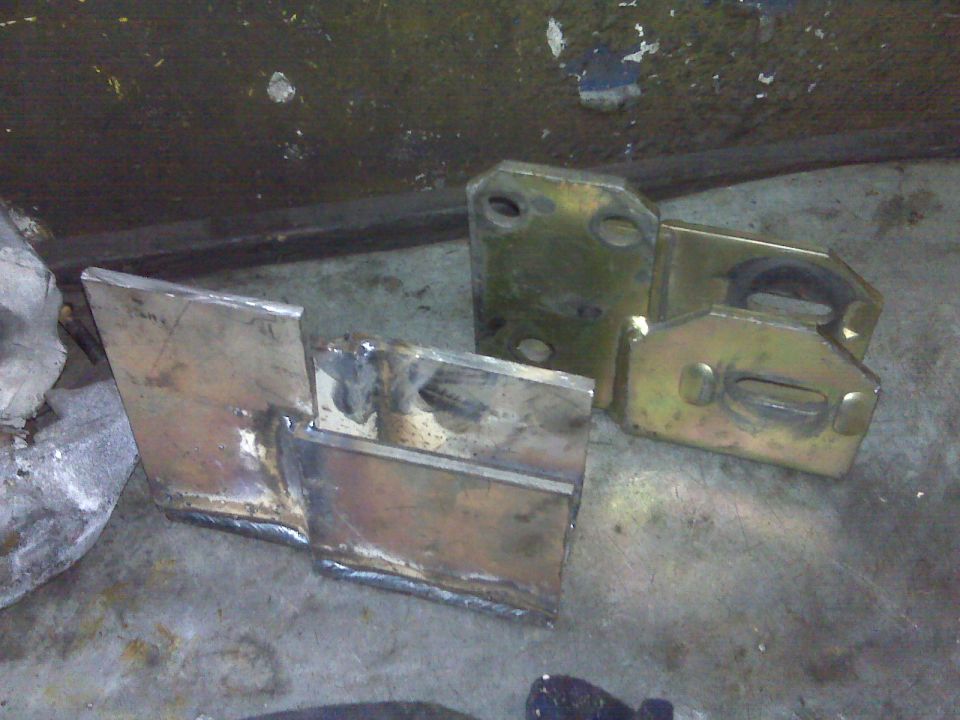 Welded metal brackets and yellow-coated components on a concrete floor