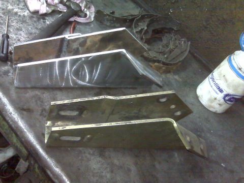 1980 Ford Bronco - Metal brackets on a workbench with tools and a bottle.