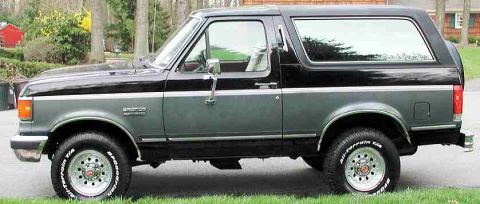 1989 Ford Bronco - This two-tone Ford Bronco is shown from the side, with its tires and body details visible.