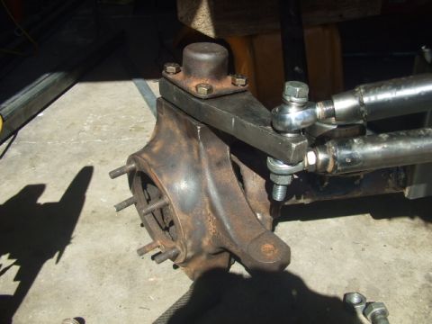1994 Jeep Cherokee - Close-up of a heavily rusted vehicle suspension part, possibly a steering knuckle, with attached tie rod ends.