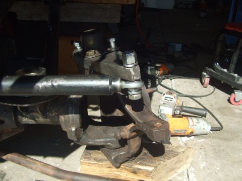 1994 Jeep Cherokee - A close-up view of a vehicle's suspension component, possibly a tie rod end, with power tools in the background.
