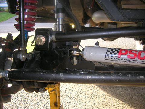1996 Ford Bronco - Close-up of a PSC steering assist cylinder and suspension parts on a vehicle.