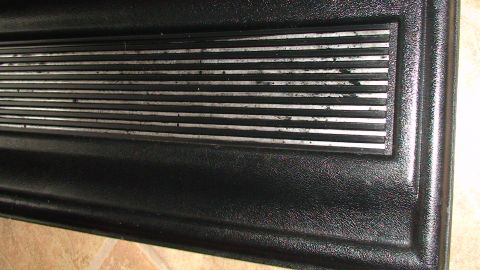 1979 Ford Bronco - This image shows a close-up of a black textured panel with a series of horizontal silver stripes.