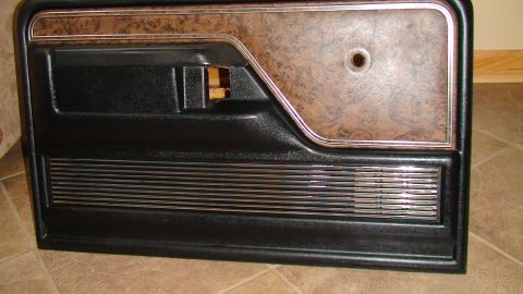 1979 Ford Bronco - This is a close-up of a car door panel, faux wood grain and chrome accents.