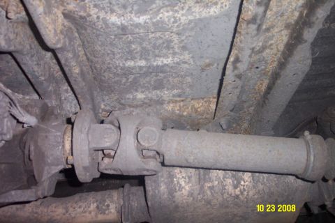1992 Ford Bronco - Undercarriage view of a vehicle's driveshaft and frame, exhibiting signs of rust and age.