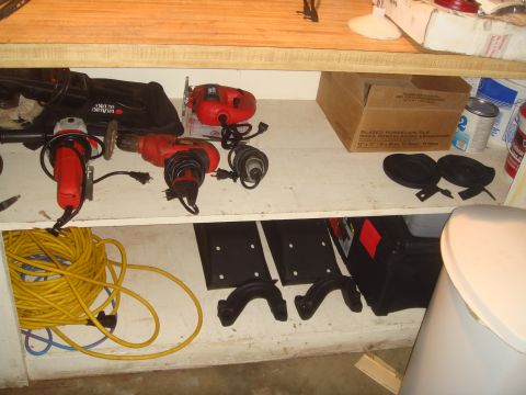 1992 Ford Bronco - Shelves are filled with various power tools, a coiled extension cord, and black mounting hardware.
