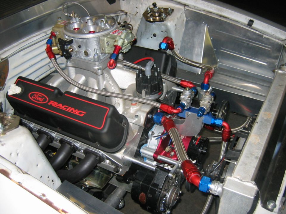 Close-up of a Ford Racing engine with custom fuel lines and carburetor