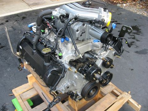 2007 Ford Mustang - A Ford SVT supercharged engine is shown, mounted on a wooden pallet outdoors.