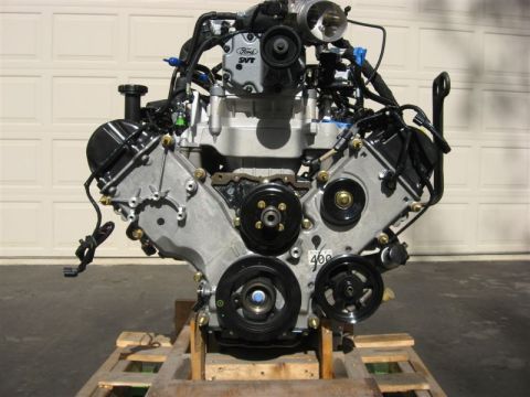 2007 Ford Mustang - A Ford SVT engine is displayed on a wooden pallet in front of a garage door.