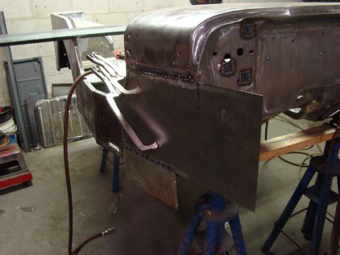 1948 Jeep Wrangler - A vehicle body is being worked on, with clamps and welding equipment visible.